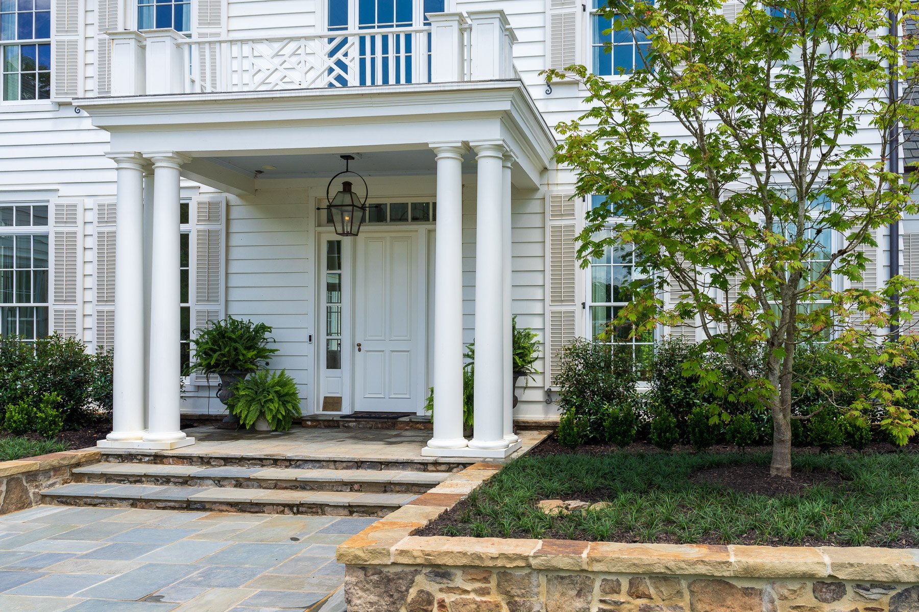 home entry stoen wall capstone steps planting bed trees