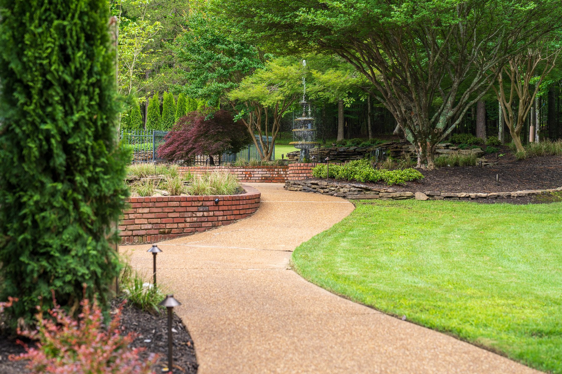 sidewalk brick wall path lights lawn water feature fountain