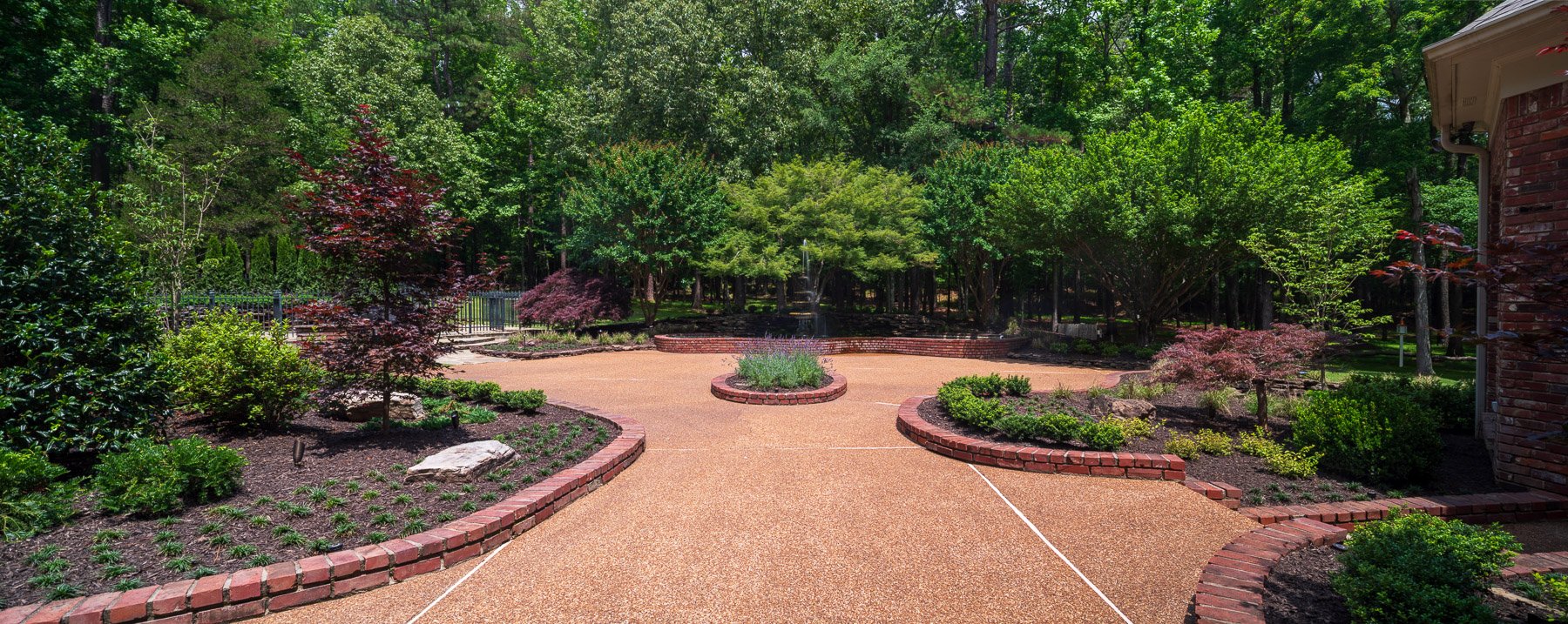 wide angle landscaping planting bed brick trees